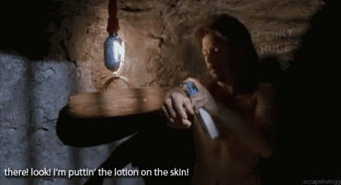 a naked man is applying lotion to his skin in front of a wall that says dirt rule
