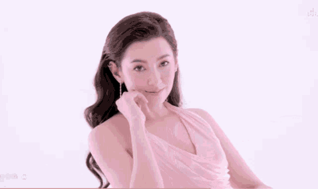 a woman in a pink dress sits in a clear chair