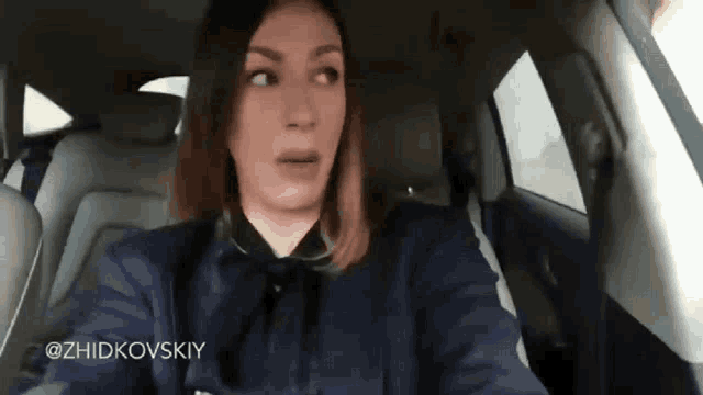 a woman is sitting in the back seat of a car with the hashtag @zhidkovsky on the bottom