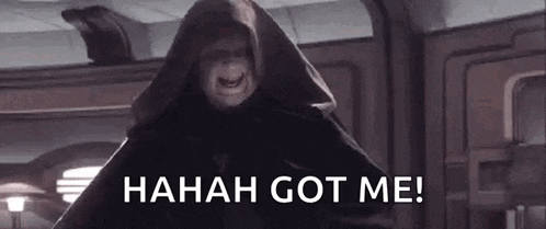 a man in a hooded robe is standing in a room and says `` hahah got me ! ''