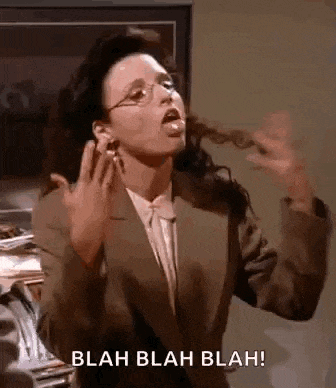 a woman in a suit and glasses is making a funny face while talking on a phone .