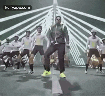 a man is dancing with a group of people on a bridge .