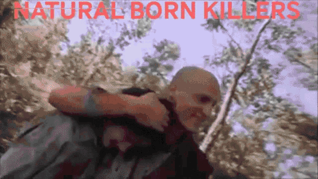 a man carrying another man with the words natural born killers written on the bottom