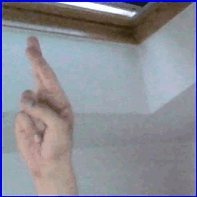 a person 's hand is crossed over their fingers in front of a window