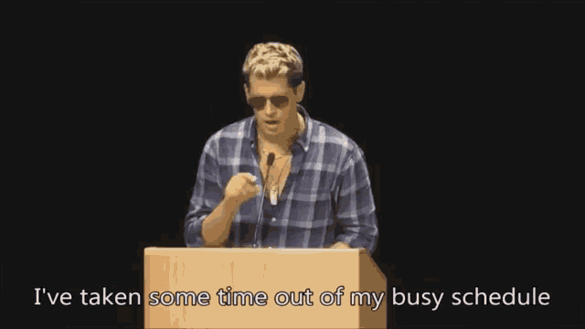 a man standing at a podium with the words i 've taken some time out of my busy schedule