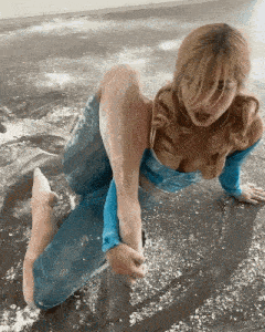 a woman in a blue top and blue pants is laying on the floor