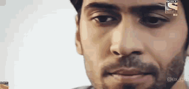 a close up of a man 's face with a sony logo on the bottom right corner .