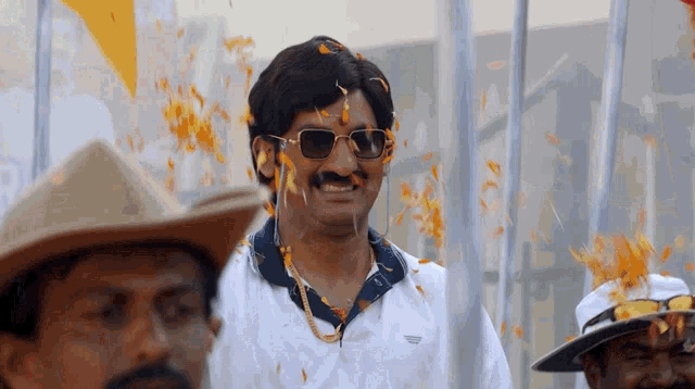 a man wearing sunglasses and a white shirt has flowers coming out of his mouth