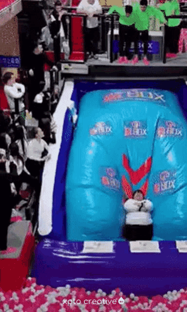 a person is sitting on top of a large inflatable slide with the word relax on it