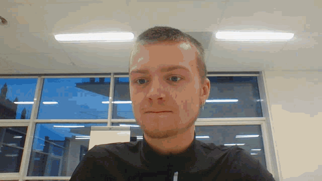 a man in a black shirt looks at the camera