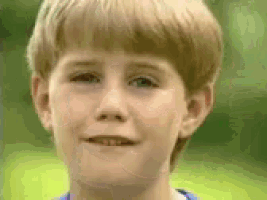 a close up of a young boy 's face with a blurred background .