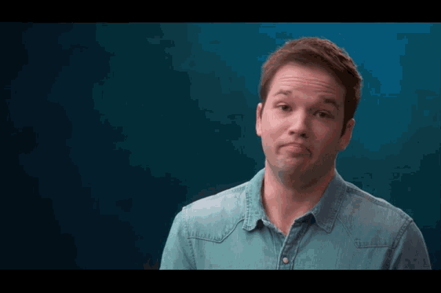 a man in a blue shirt is making a silly face