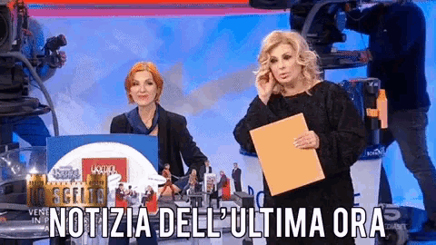 a woman holding a piece of paper that says ' notizie dell ' ultima ora ' on the bottom