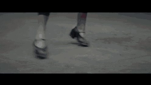 a close up of a person 's legs with red shoes on