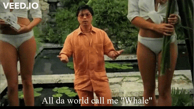 a man in an orange shirt is standing in front of two women in bikinis and says " all da world call me "