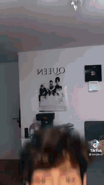 a man is standing in front of a wall with a picture of a group of people on it