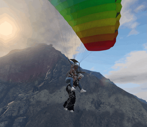 a rainbow colored parachute is being used to fly two people
