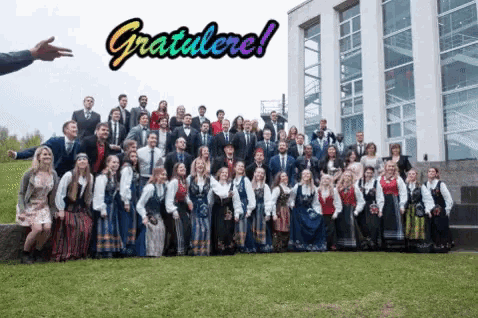 a large group of people standing in front of a building with the words gratulerer written above them