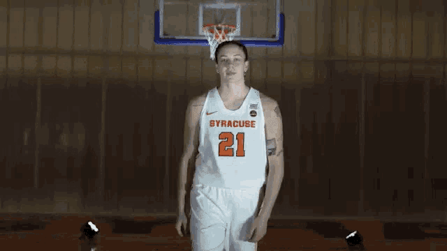 a female basketball player is posing for a picture with her arms crossed .