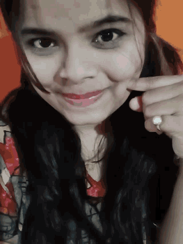 a woman with a ring on her finger is smiling for the camera