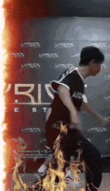 a man is dancing in front of a wall that has lyrics on it