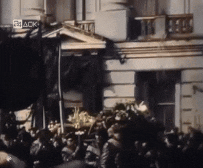 a crowd of people are gathered in front of a building with a sign that says 24 ack on it