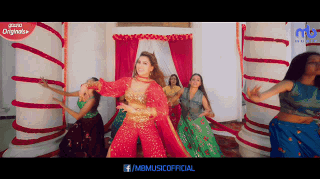 a woman in a red dress is dancing in front of a group of other women
