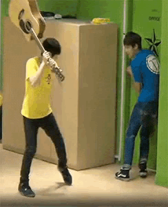 a man in a yellow shirt is holding a guitar