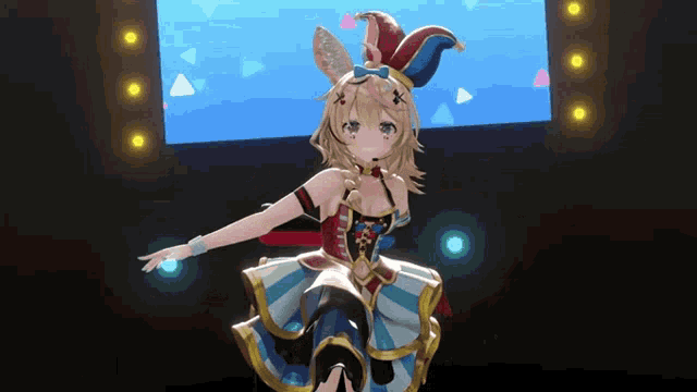 a girl in a jester hat is dancing on a stage in front of a large screen .