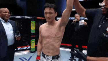a man in a boxing ring with a can of monster energy in the background