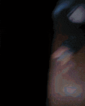 a blurry picture of a person laying on a blanket in the dark
