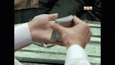 a man is holding a stack of playing cards in front of a box that says ' ic coated ' on it