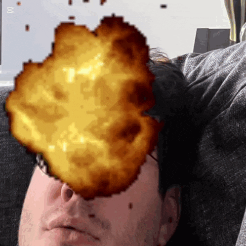a man laying on a couch with an explosion coming out of his face