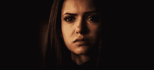 a close up of a woman 's face in a dark room .