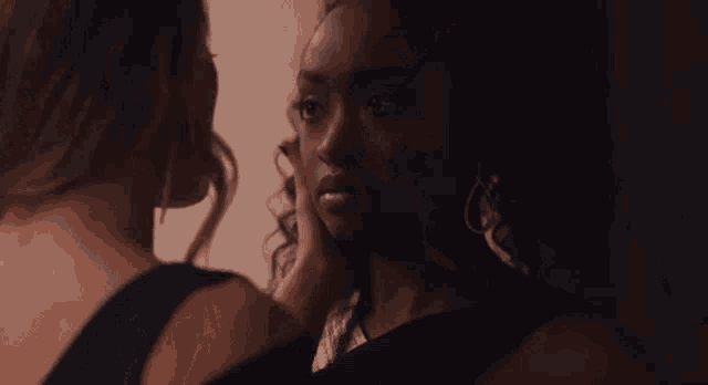 two women are touching each other 's faces .