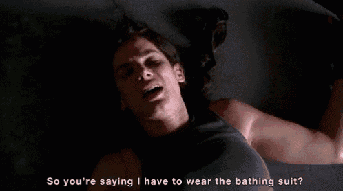 a woman is laying on a bed and says " so you 're saying i have to wear the bathing suit ? "