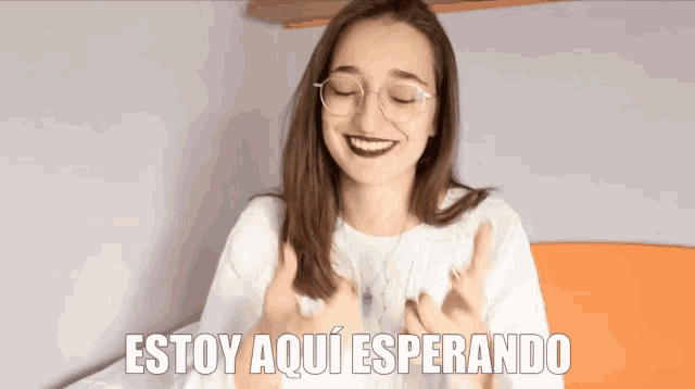 a woman giving a thumbs up with the words estoy aqui esperando above her