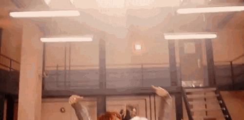 a group of people are dancing in a room with a lot of lights .