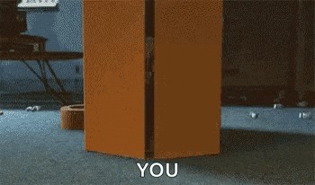 a person is standing in a room with a box that says `` you '' .