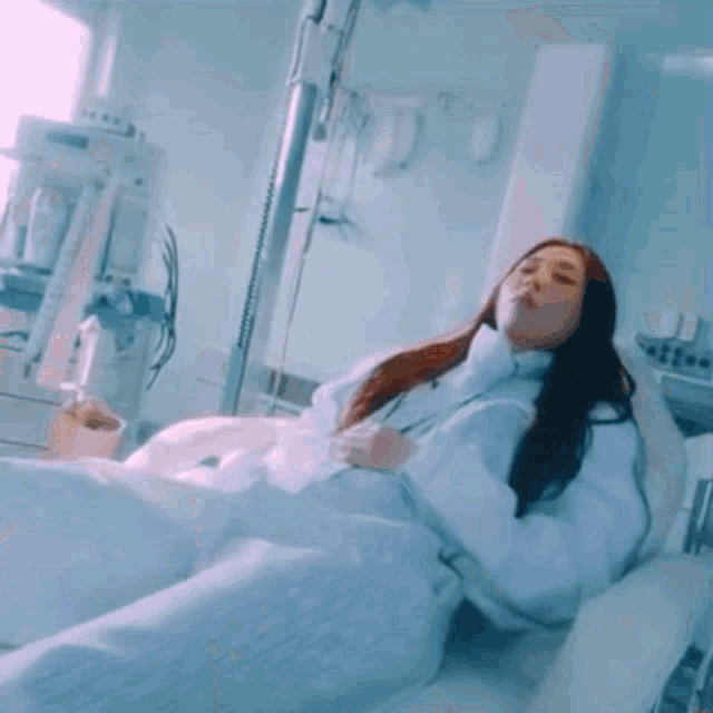 a woman is laying in a hospital bed with a drip .