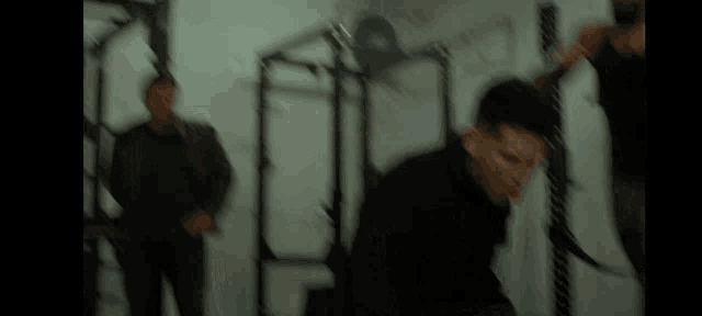 a blurry picture of a man in a black jacket standing in a dark room