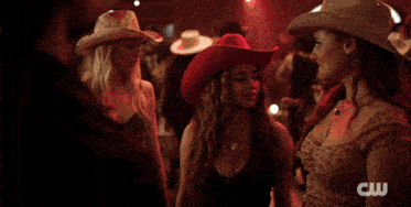 a man in a cowboy hat and a woman in a cowboy hat are dancing together
