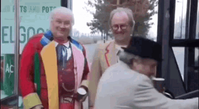 a group of men dressed up in costumes are standing next to each other .