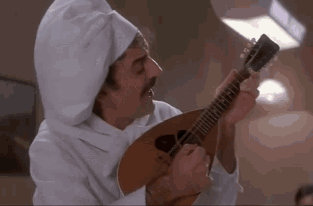 a man wearing a chef hat is playing a guitar