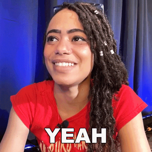 a woman in a red shirt is smiling and says " yeah "