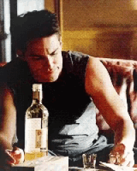 a man is sitting on a couch with a bottle of ketel one