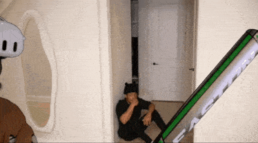 a man sitting in a hallway next to a phone that says ' stealth ' on it
