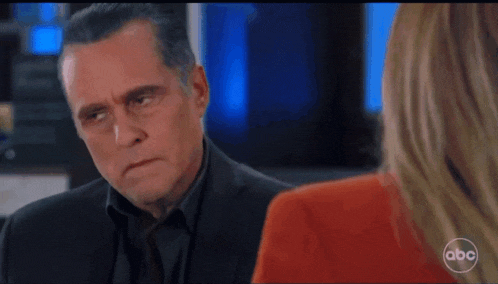 a man in a suit is talking to a woman with abc written on the bottom