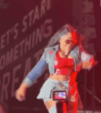 a woman in a red dress is holding a microphone in her hand