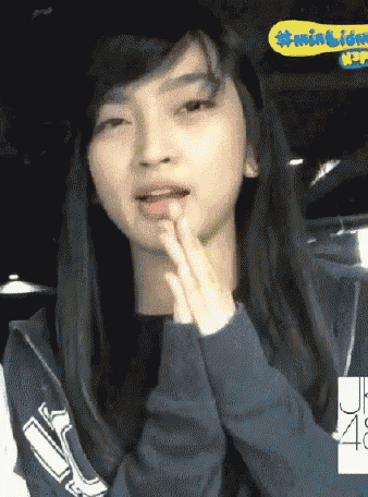 a girl wearing a blue hoodie with the number 48 on the sleeve